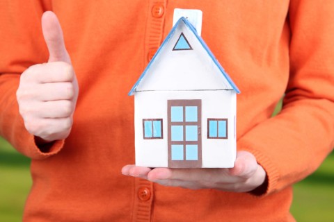 Thumbs Up Holding a Model of a Home